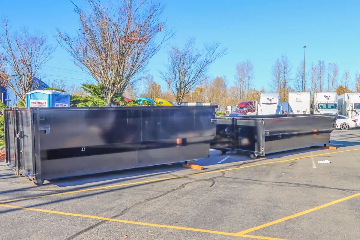 Professional dumpster rental service with roll-off container on residential driveway in Huntington Woods